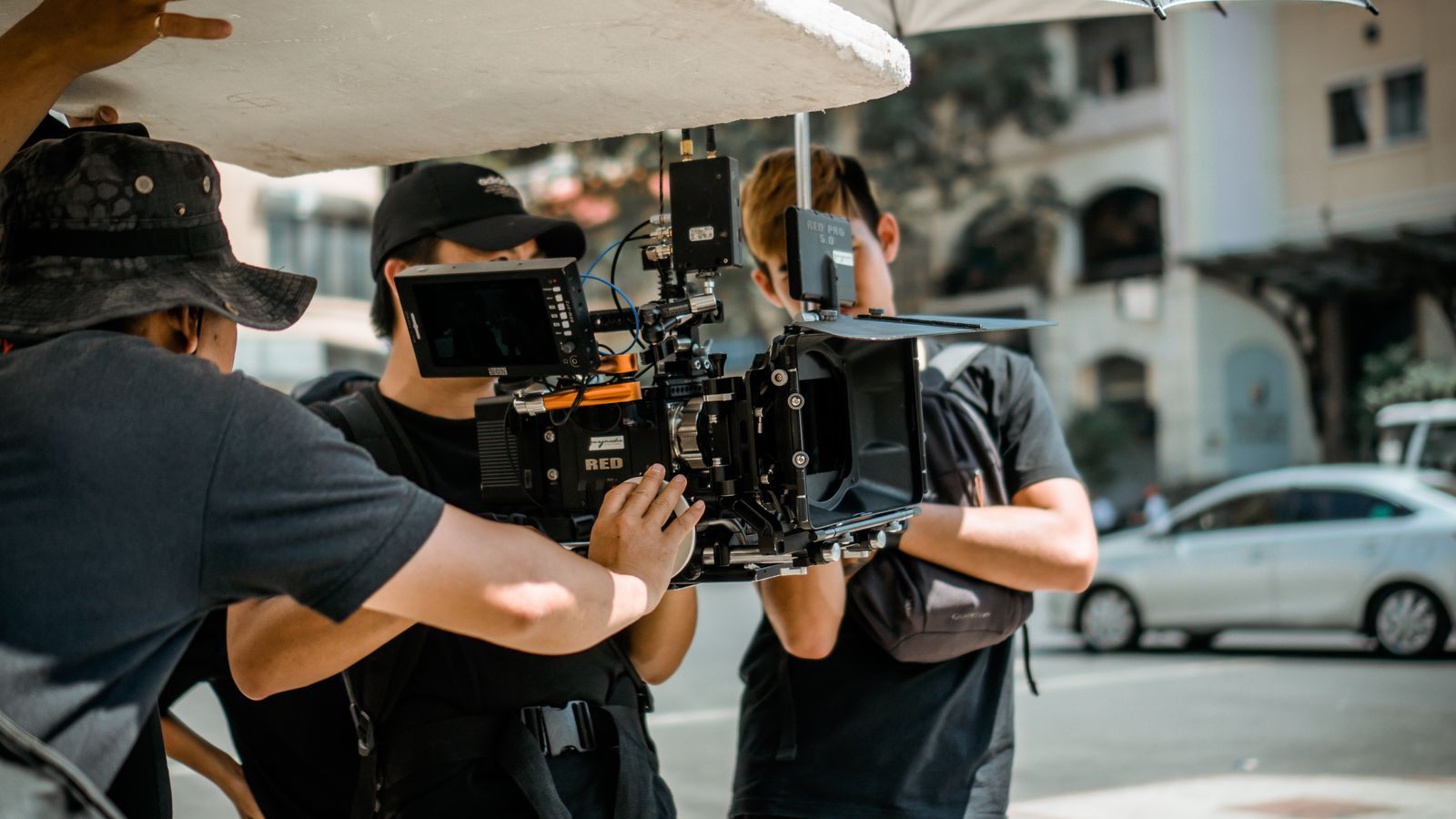 Film crew on location with a cinema camera, the way cruise shows on TV are shot