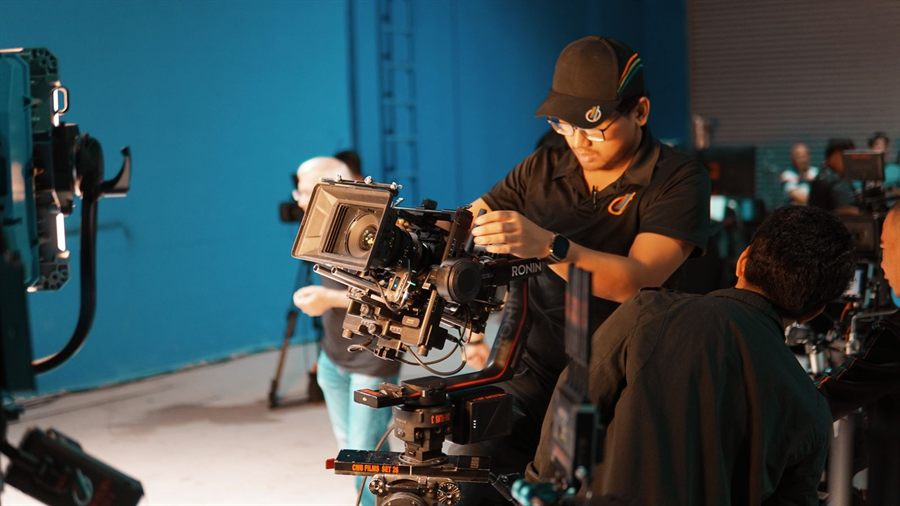 Camera operator setting up a studio shot of the kind used on a cruise TV show